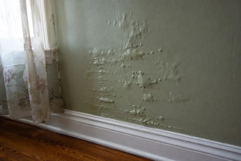 wall with bubbling pain inside Raleigh, NC home indicating water damage
